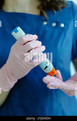 Doctor is demonstrating auto-injector syringe as an emergency treatment for allergic reaction. Stock Photo