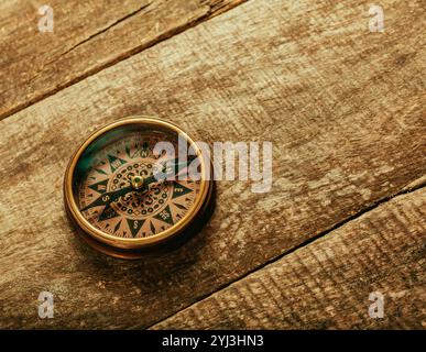 old-fashioned compass on rustic wooden table Stock Photo