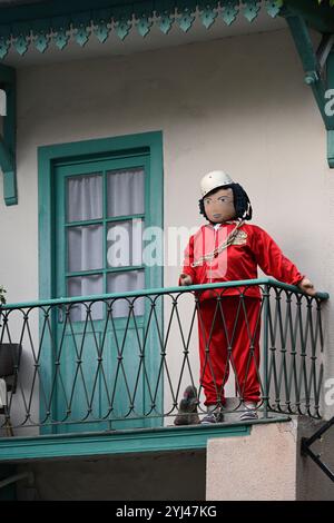 Mounaque of Campan, Tall Doll or Puppet on Balcony of Traditional Village House, Campan Hautes-Pyrénées Pyrenees France Stock Photo