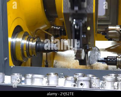 CNC machine cutting thread on pipe fitting. Stock Photo
