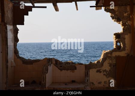 broken wall with sea background, old building , sea view from old derelict building, old wall, fallen wall, empty concept, desolate war, destruction Stock Photo