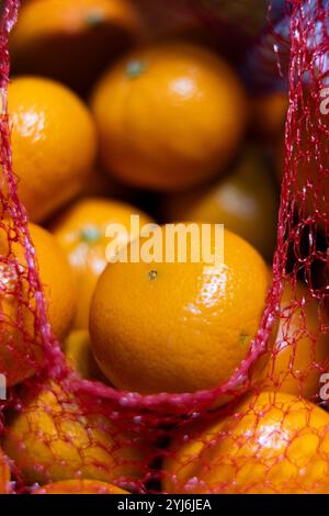 mandarin oranges come in a bright red mesh bag that makes it so you can see the oranges through the opening. This makes the oranges look very tasty an Stock Photo