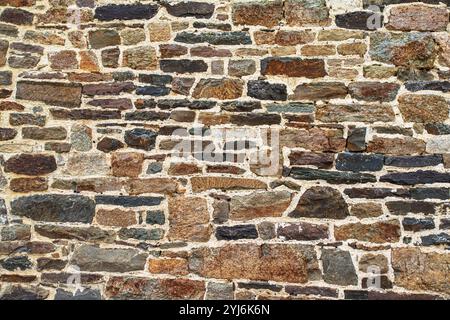 Texture of an old stone wall in brown, red and black Stock Photo