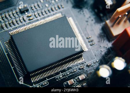 A CloseUp View of a Microchip Seated on a Circuit Board with Various Technological Elements Stock Photo