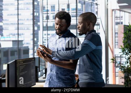 Team of technicians working with machine learning tech advancing AI innovating autonomous systems. Teamworking IT coworkers in office transforming data into predictive models Stock Photo