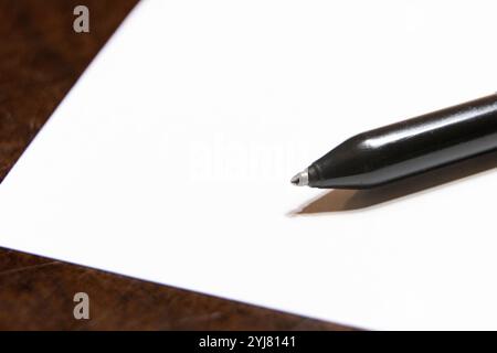 Close up of a black ballpoint pen on a white background with copy space. Prepping to write notes. Thinking. Blank space. Stock Photo