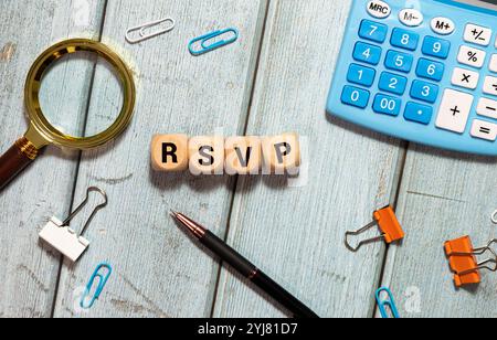 rsvp acronym request for a response from the invited person on wooden cubes with female hand. Stock Photo