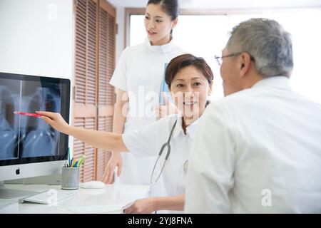 Senior male patients and nurses visiting a female doctor Stock Photo