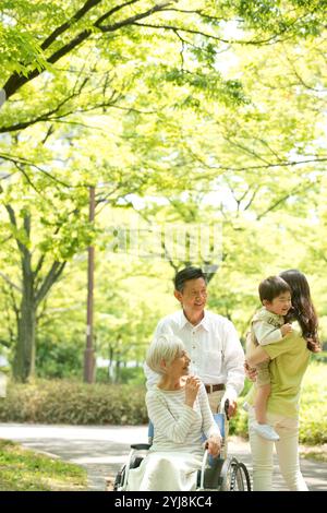 Elderly couple in wheelchair and woman holding child Stock Photo