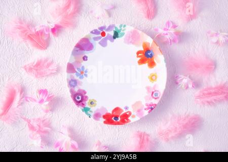 Floral dish placed on pink washi paper with pink feathers and flowers Stock Photo