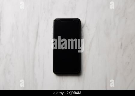 Smartphone placed on marble baking sheet Stock Photo