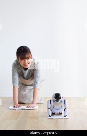 Woman hanging rag with robot Stock Photo - Alamy