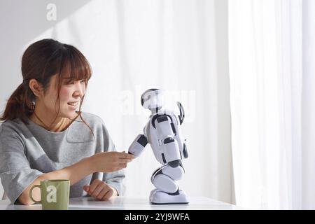 Woman shaking hands with robot Stock Photo