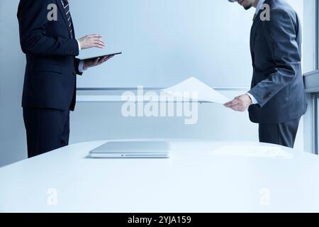 Two men facing the whiteboard Stock Photo