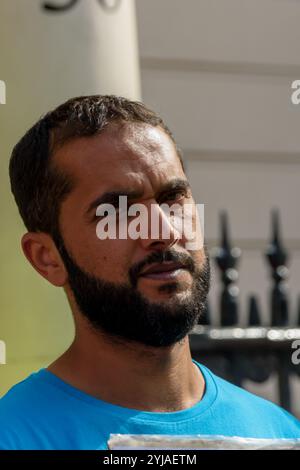 London, UK. 13th August 2018.  Hunger striker Ali Mushaima who has been outside the Bahrain Embassy in Belgrave Square since August 1st, asking for his 70-year old father in prison in Bahrain to be given urgently needed medical care, family visits and access to books who was was attacked early on Sunday morning by staff inside the embassy, with a bucket of an unknown liquid being thrown on him from the  ambassador's balcony stands with the protesters. His father, Hassan Mushaima and other human rights defenders and opposition leaders were abducted in March 2017, brutally tortured and given lif Stock Photo