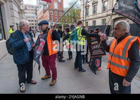 London, UK. 1st May 2018. A member of the public talks to Alberto Durango of the Cleaners and Allied Independent Workers Union as they protest outside the Royal Opera House.  Alberto complains that he was told he should not be protesting here as he is not British. CAIWU celebrated International Workers' Day with an open-topped bus tour stopping to protest outside some of London's most notorious employers where CAIWU is in dispute over a living wage, conditions of service and bullying management. Companies protect their reputations by employing contracting companies to manage their cleaning and Stock Photo