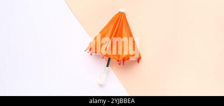 Small orange umbrella on light color background, top view Stock Photo