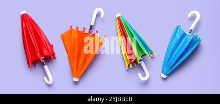 Different umbrellas on lilac background, top view Stock Photo