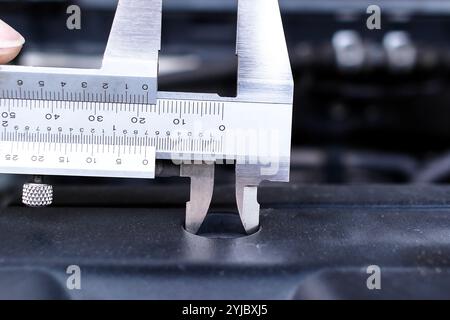 Close up of vernier caliper measuring engine component , Mechanics tool concept Stock Photo