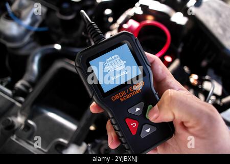 OBDII Scanner in use under the hood by auto mechanic for reading fault code of the car engine system , Car repair concept Stock Photo