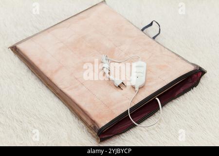 A warm new two-sided new electric sheet, lies assembled in packaging, and on top of sheet lie a temperature switch and a white fork on white backgroun Stock Photo