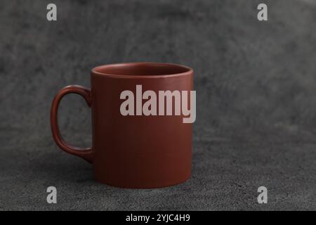 Empty Brown Ceramic Mug. Rustic Cup on Dark Grey background. Copy space. Rustic Dishes Stock Photo