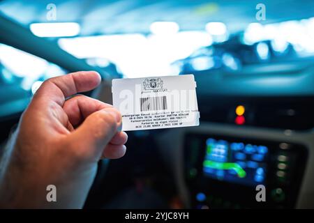 Alkmaar, Netherlands - Aug 30, 2024: Close-up of a parking ticket held inside a car in Alkmaar, Netherlands, highlighting a moment after parking payment in a Dutch parking facility Stock Photo