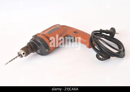 old used orange hand drilling machine on white background Stock Photo