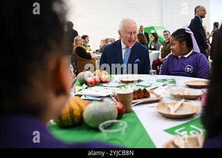 King Charles III speaks with pupils from Rye Oak Primary School as he visits the first Coronation Food Hub in Deptford, south London. The King is marking his 76th birthday and the first anniversary of The Coronation Food Project by opening the first two Coronation Food Hubs, one in person and the other virtually in Merseyside. Picture date: Thursday November 14, 2024. Stock Photo