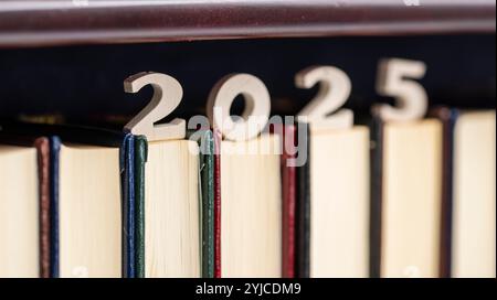 Número 2025 de madera sobre libros de una estantería de una biblioteca Stock Photo