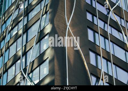 Combination of metal and glass wall material. Steel facade on columns. Abstract modern architecture. High-tech minimalist office building. Stock Photo