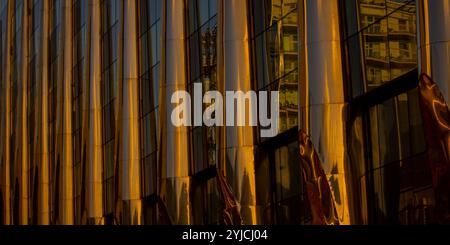 Combination of metal and glass wall material. Steel facade on columns. Abstract modern architecture. High-tech minimalist office building. Stock Photo