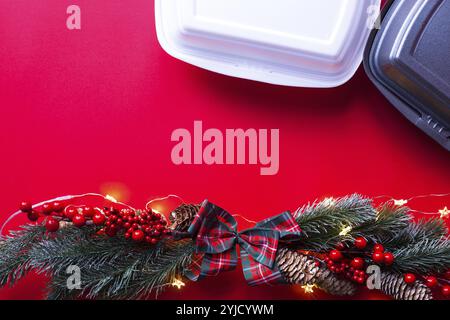 Christmas decor of food delivery service containers. New year's eve promotion. Ready-made hot order, disposable plastic and paper packaging. Work on p Stock Photo