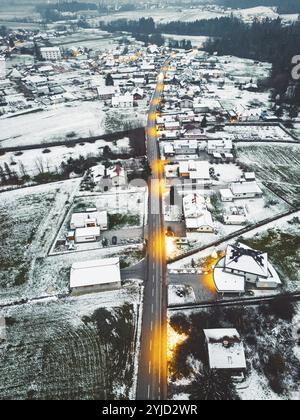 Aerial view of suburban community in winter time in the evening. Snow on the grounds, dark, street lights shining Stock Photo
