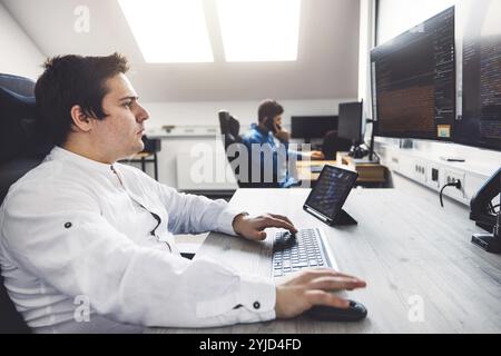 IT Programmer Working on Desktop Computer. Male Specialist Creating Innovative Software Engineer Developing App, Program, Video Game. Terminal with Co Stock Photo