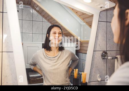 Beautiful young woman cleaning her face, removing make up with a cotton pad and micellar water. Skin care and beauty. Young beautiful woman cleaning h Stock Photo