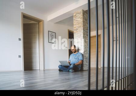 Adult caucasian man working from home a couple days a week. Adult person working from home, from different rooms in the house, in the kitchen, dining Stock Photo