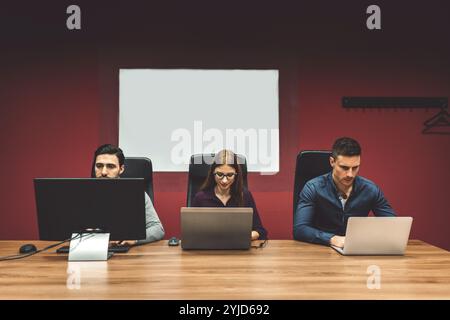 Start up company, young caucasian business people at work, brainstorming ideas, working on computers coding. Colorful offices with young people workin Stock Photo