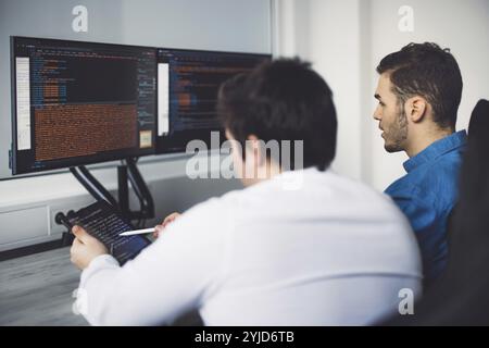 IT Programmer Working on Desktop Computer. Male Specialist Creating Innovative Software Engineer Developing App, Program, Video Game. Terminal with Co Stock Photo