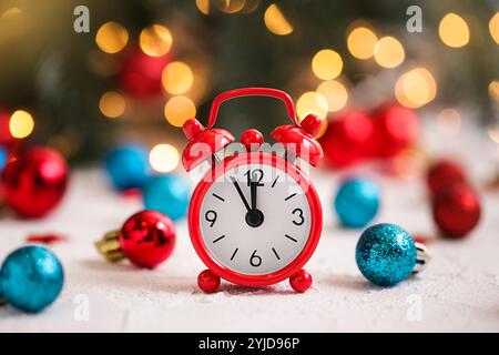 Christmas Time. Alarm Clock and red, blue christmas Ornamens on white table. Stock Photo