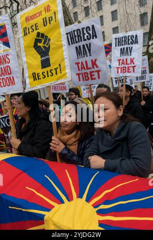 London, UK. 10th March 2018. People face Downing St with placards 'Theresa May Talk Tibet'  at the rally before the annual Tibet freedom march in London commemorating the 59th anniversary of the Tibetan National Uprising. Several hundreds of people, including many Tibetans and supporters gather at Downing St before marching to a protest at the Chinese Embassy. Before the march left there was a minute of silence for those who have died, including by self-immolation, and a long Tibetan prayer, followed by the singing of the Tibetan National Anthem. Stock Photo