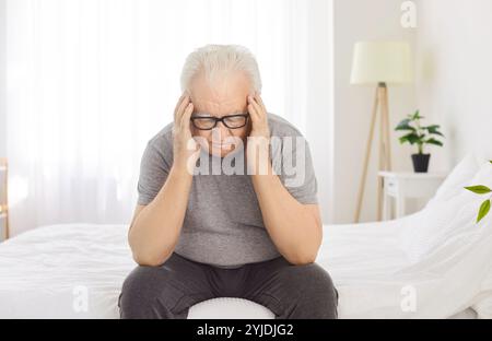 Elderly Man Suffering From A Headache Or Migraine At Home Stock Photo