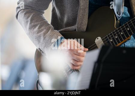 Guitarist on stage for background, soft and blur concept. Close up hand playing guitar. Musician playing guitar, live music background. Stock Photo