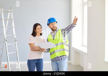 Skilled professional repairman explaining, architect construction worker with talking to client  Stock Photo