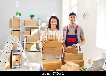 Portrait of man worker from delivery service and female small business owner in warehouse Stock Photo