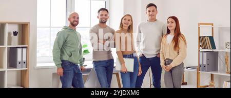 Young people group wearing casual clothes looking at camera and smiling standing in office. Stock Photo