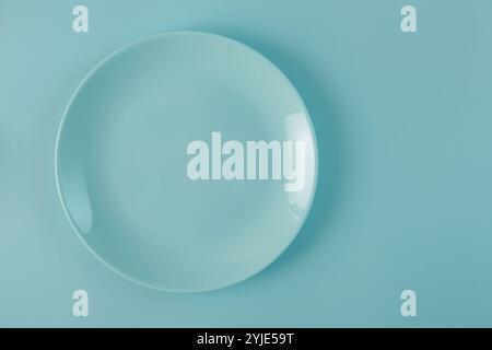 empty blue plate on same colored blue background. Top view. mock up Stock Photo