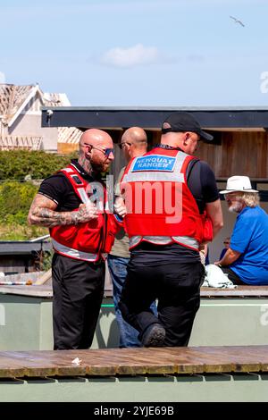 Two Newquay Rangers chat to people enjoying the good weather on Killacourt, Newquay, Cornwall, UK Stock Photo