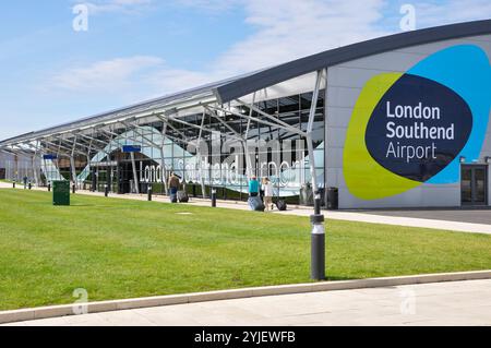 London Southend Airport. Passengers with luggage heading towards the terminal building, with London Southend Airport logo, symbol Stock Photo