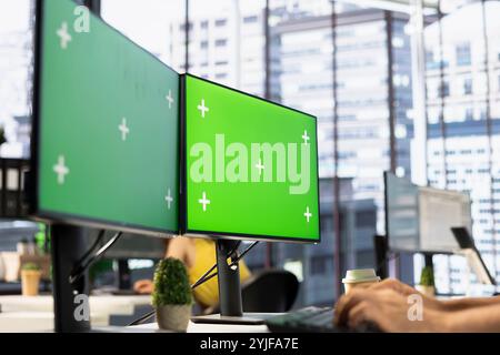 IT employee in office working on green screen computer, testing and deploying programs and systems. Programmer checking code on chroma key desktop PC, solving tasks in workspace Stock Photo